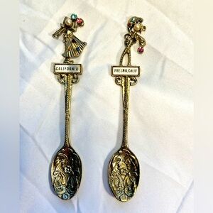 Lot of two Collectible Gold tone souvenir Spoons, with  dancing figure on top.
